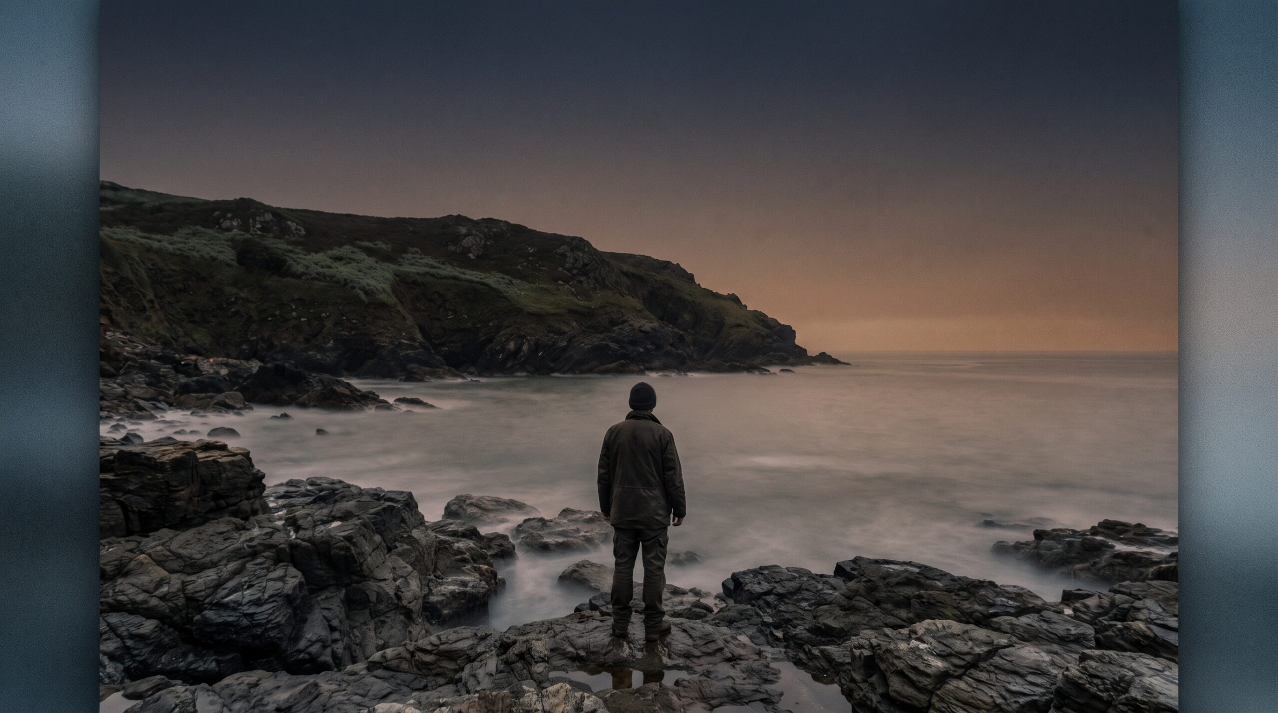 Lone figure on wet rocks watching a calm dawn sea, the mood behind these ocean and coast quotes
