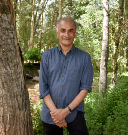 Pico Iyer travel quotes - portrait standing next to a tree