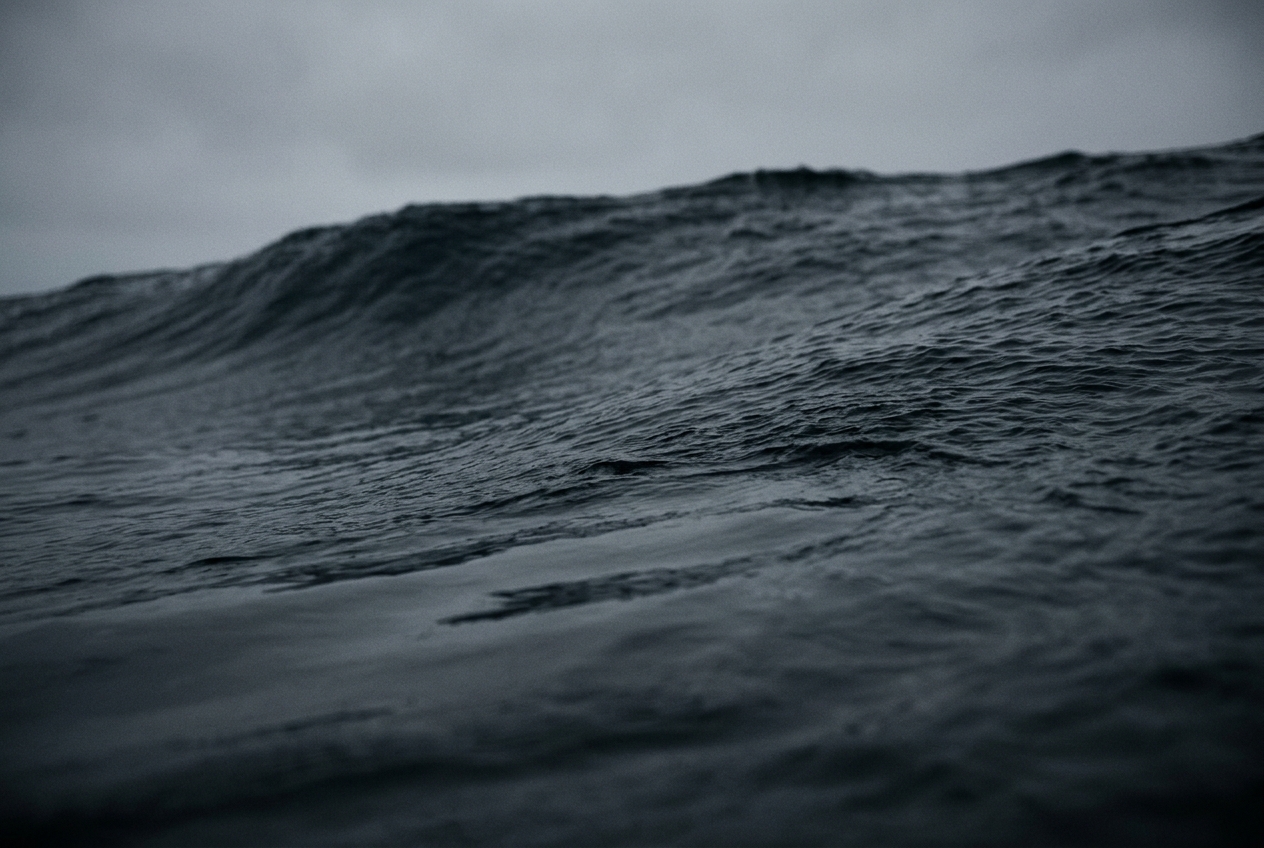 Close view of a deep-water swell, glassy in the trough and dark beneath the surface used for sea quotes